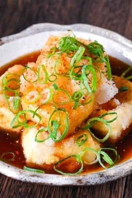 Agedashi Tofu (Japanese deep fried tofu) in a thick sauce topped with chopped spring onions, grated daikon and shichimi pepper