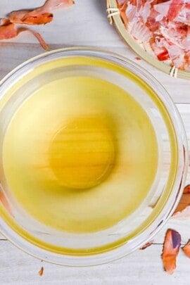 Katsuo (bonito flake) dashi in a glass bowl surrounded by bonito flakes