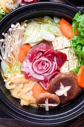 Botan nabe served in a black hot pot and made with wild boar shaped like a peony flower