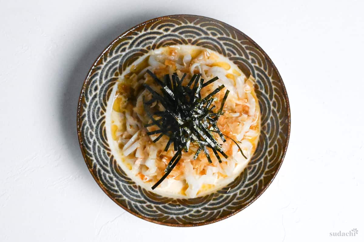 daikon salad topped with shredded kizami nori in a ceramic bowl with Japanese wave design