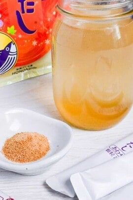 dashi made with granules in a jar surrounded by various packs of dashi granules