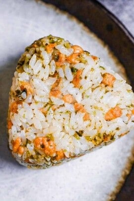 devil's onigiri made with tempura flakes and aonori on a gray plate with a brown border