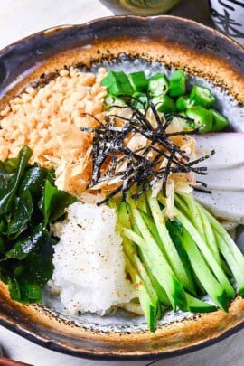 Hiyashi tanuki udon topped with tenkasu, okra, wakame, grated daikon, kamaboko, cucumber, katsuobushi and kizami nori