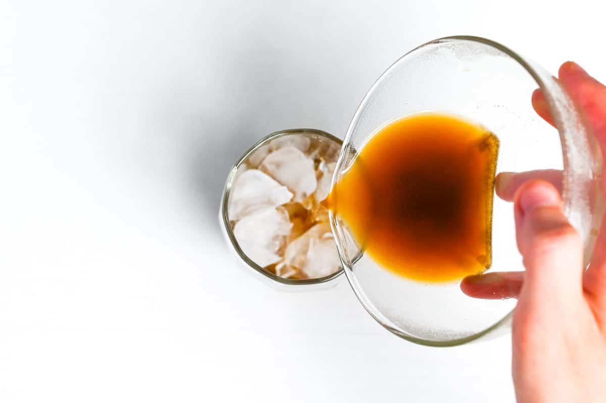pouring concentrated hojicha over ice in a glass