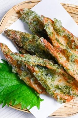 Chikuwa isobeage on a bamboo tray with tempura paper and a shiso leaf