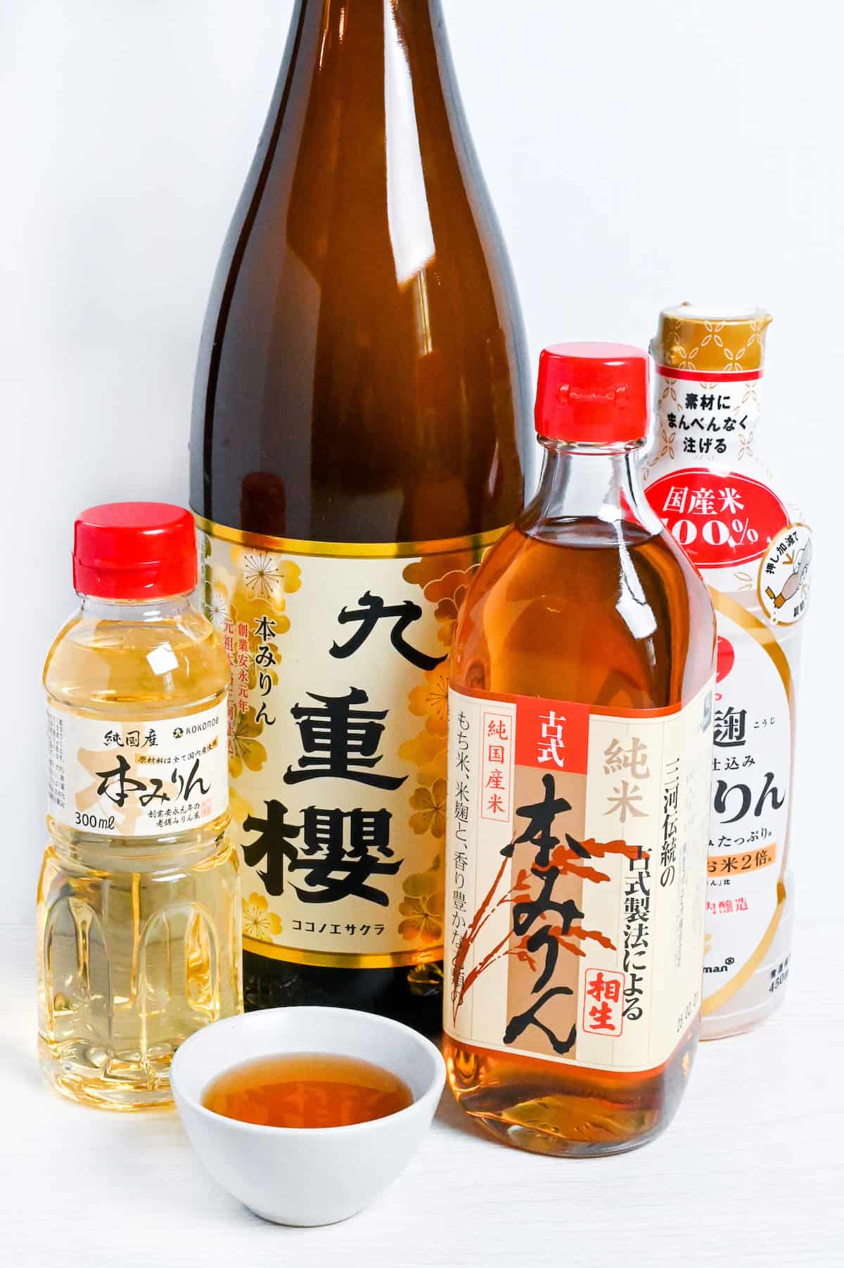 Bottles of Japanese hon mirin (Sweet rice wine seasoning) with some poured in a small white bowl