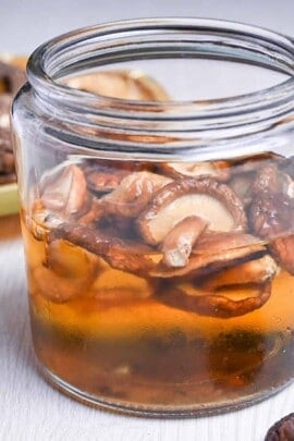 shiitake dashi in a jar next to loose dried shiitake mushrooms