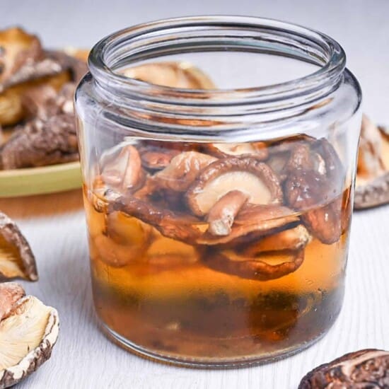 shiitake dashi in a jar next to loose dried shiitake mushrooms