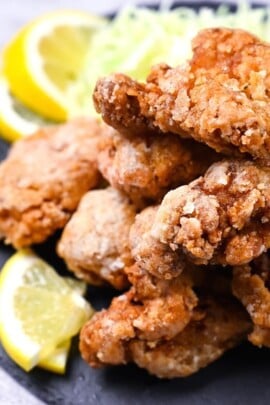 Japanese chicken tatsuta age served on a slate slate with cabbage and lemon