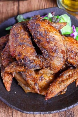 Yamachan Style Fried Chicken Wings (Nagoya Tebasaki) stacked on a dark plate with salad