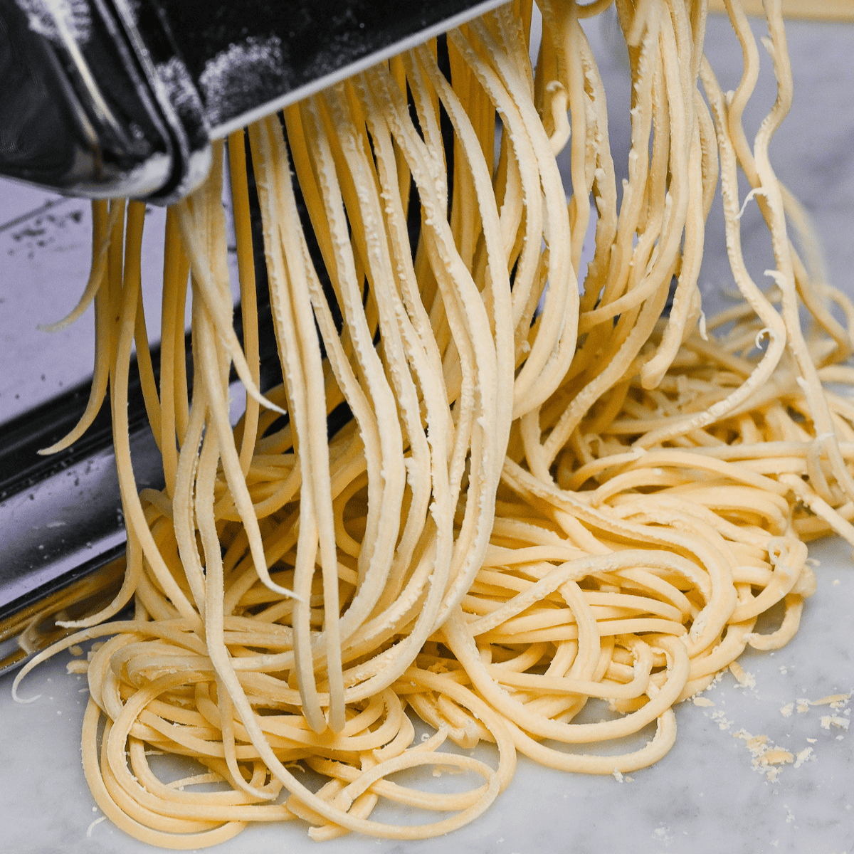 A close up of a pasta machine with spaghetti.