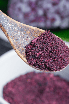Homemade yukari red/purple shiso rice seasoning powder heaped on a brown ceramic spoon