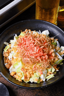 monjayaki ingredients in a black bowl next to an electric griddle